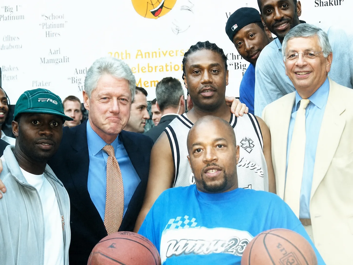 Robert Gus Wells in a blue shirt holding basketballs alongside figures from Rucker history